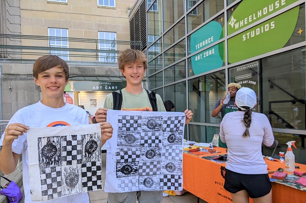 Participants hold up art prints they created at Terrace Art Zone