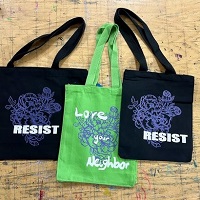 Three tote bags with text "resist" and "love your neighbor" 