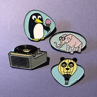Vintage-style enamel pins featuring a penguin, elephant and more