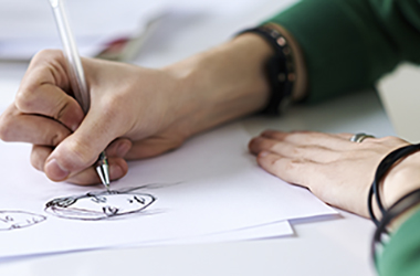 Closeup of someone drawing a face with a pen