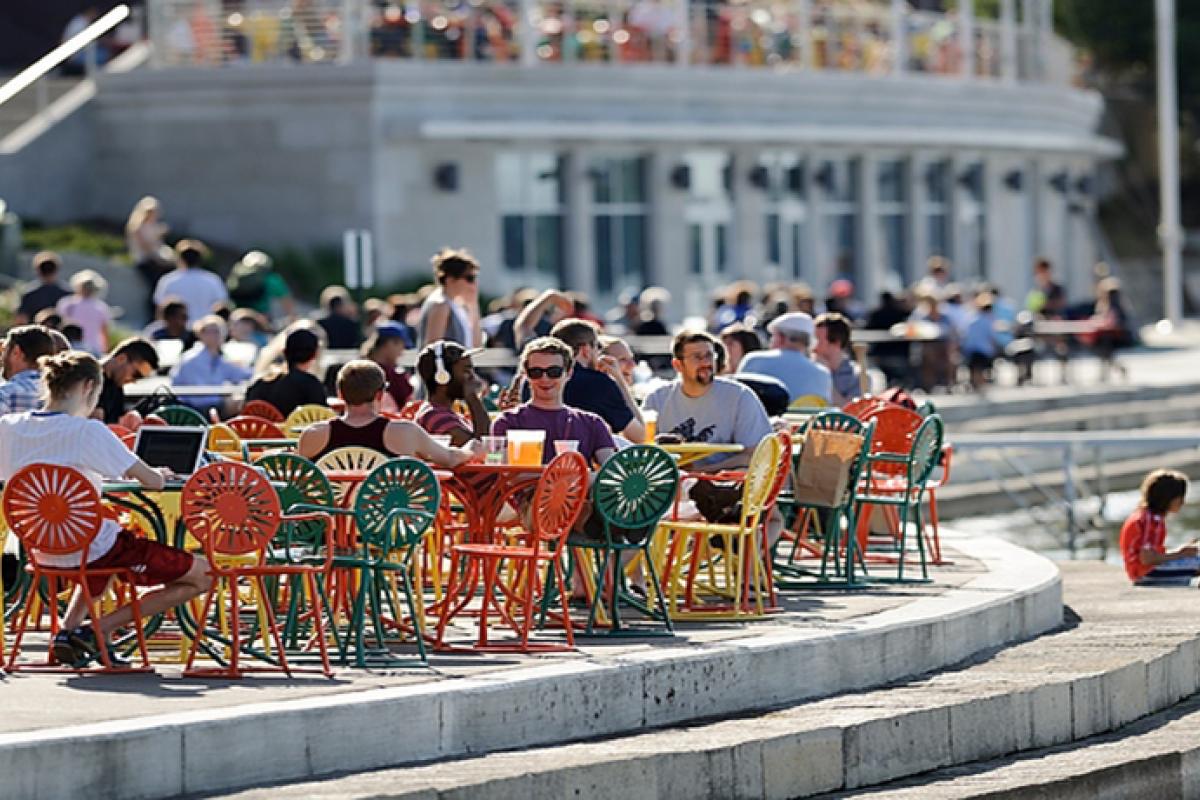 Visitors hanging out at tables on the lakeside Memorial Union Terrace