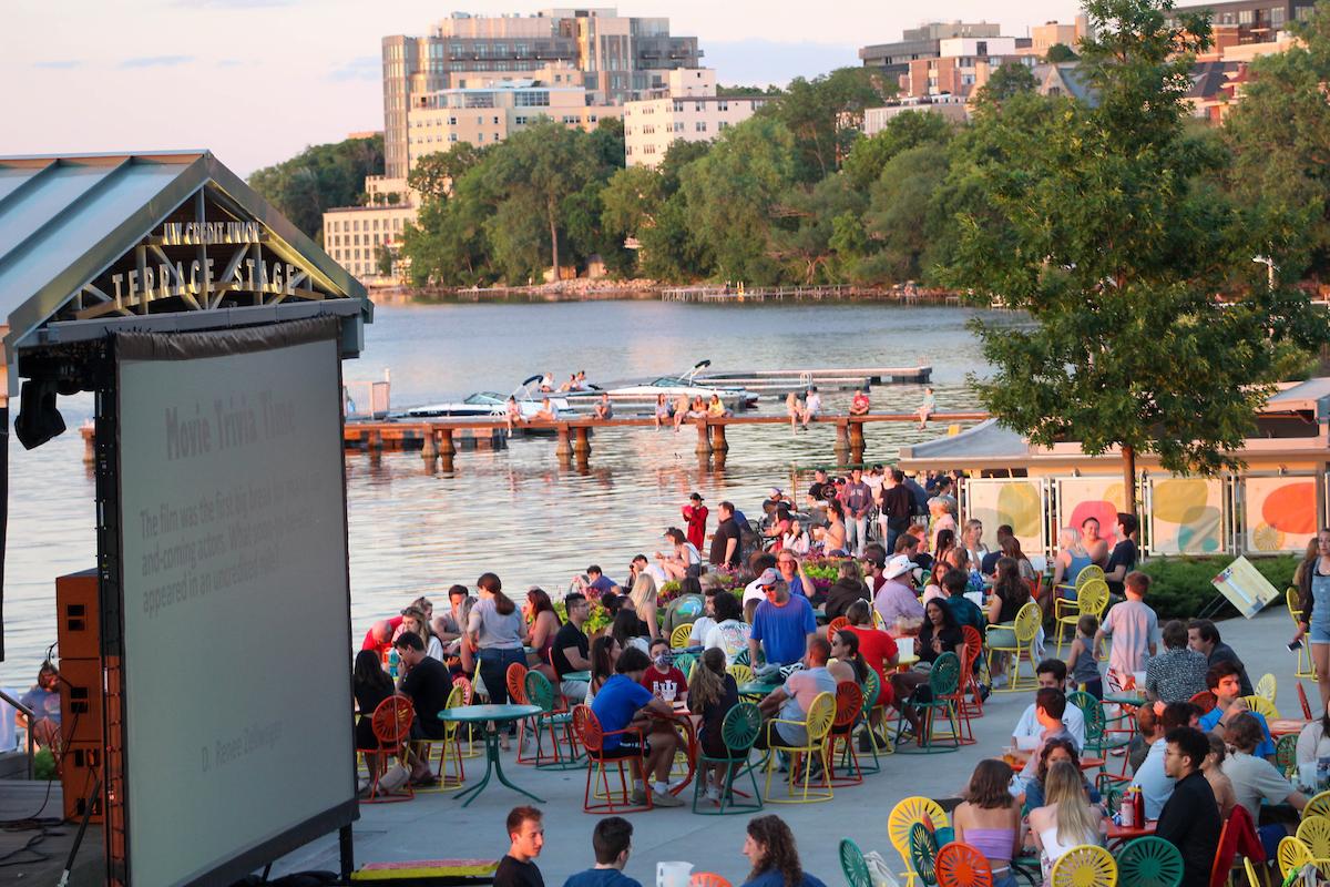 People watching a film on a large screen on the Terrace, next to the lake