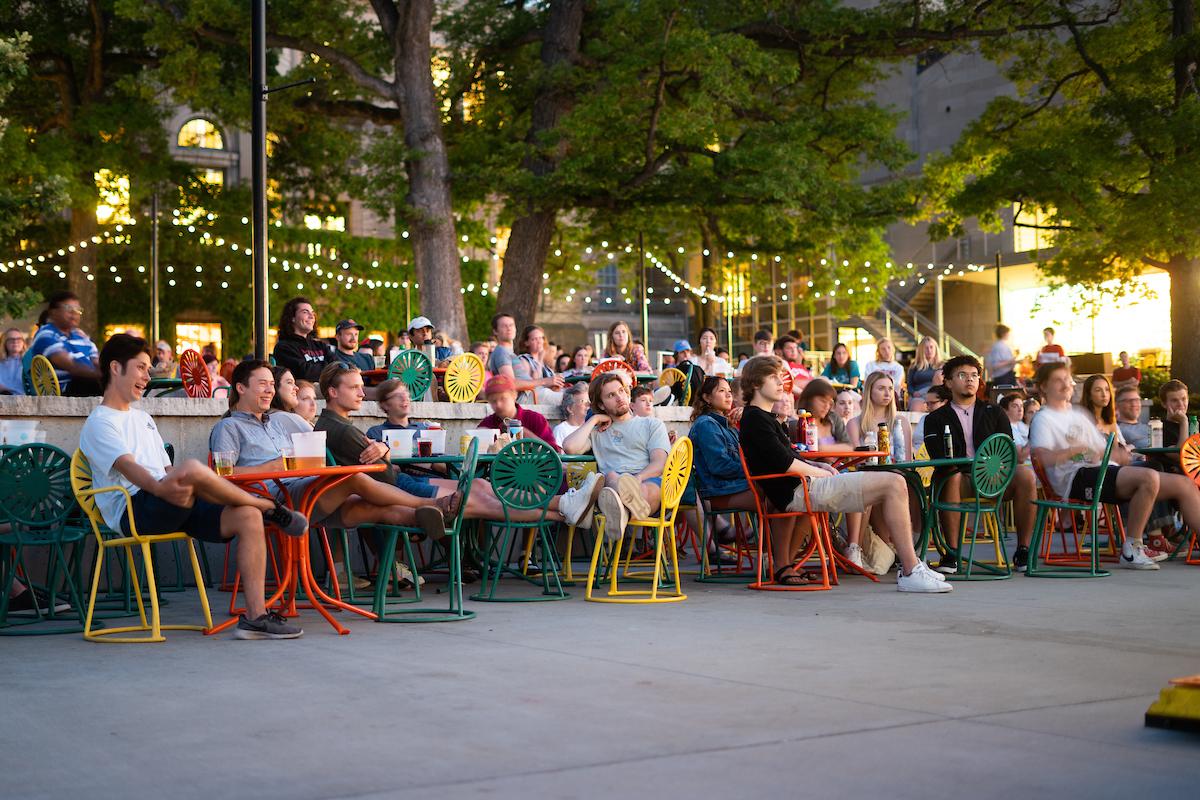 People gathered on the Terrace to watch a film, string lights in the background