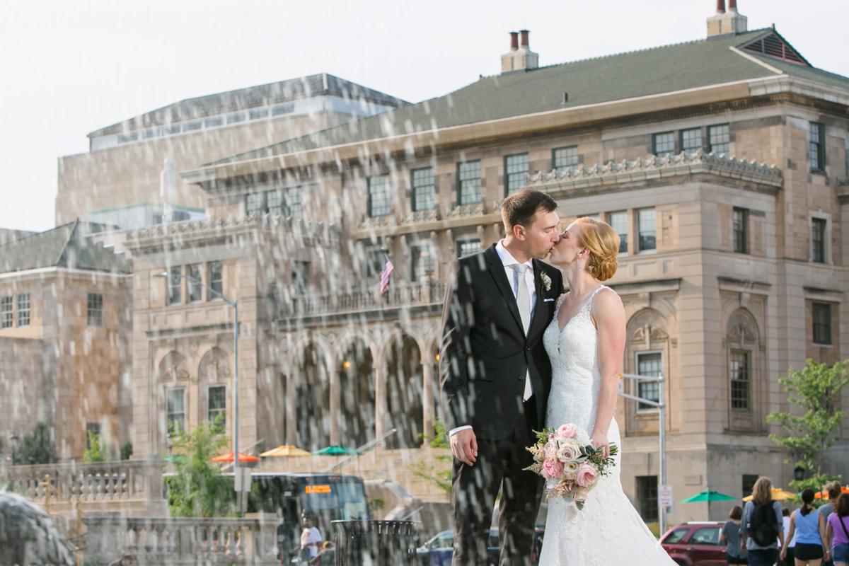 Bride and groom kiss near the fountain in front of Memorial Union