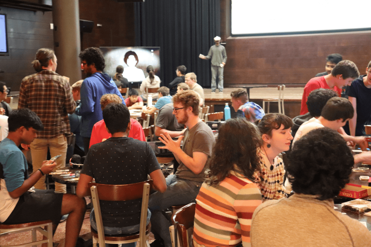 People are gathered playing board games and a VR game