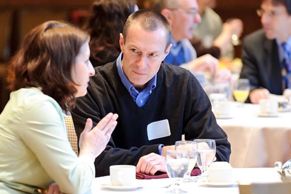 Two people talking at a table during a business luncheon meeting