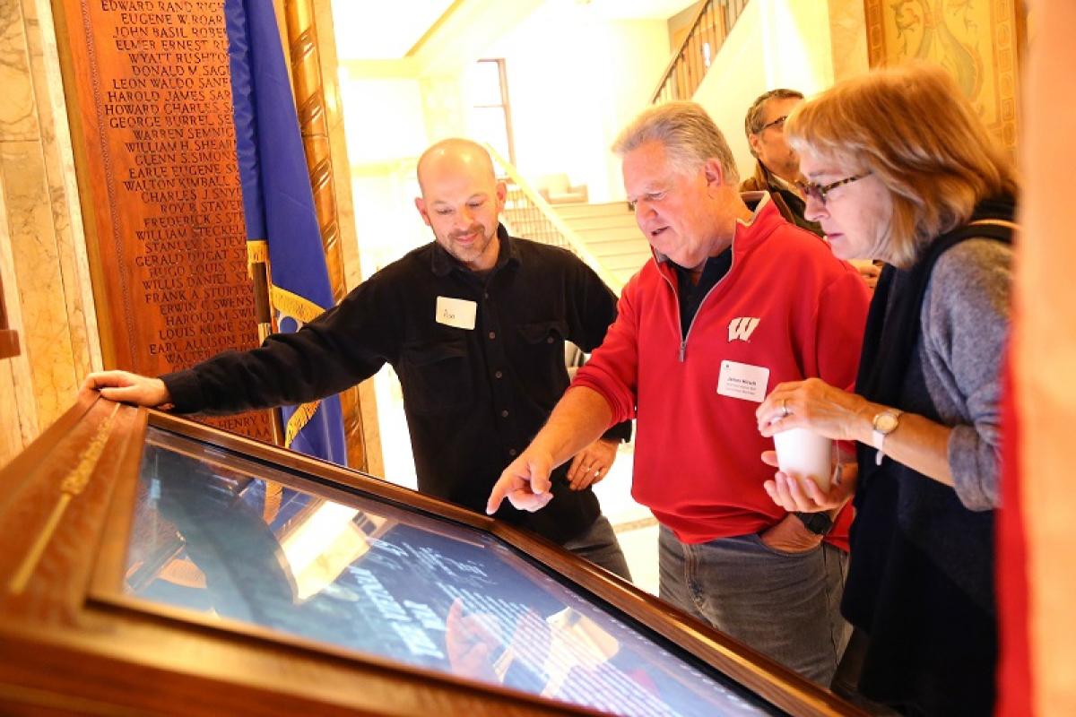 People gathered around the Gold Star Honor Roll digital display
