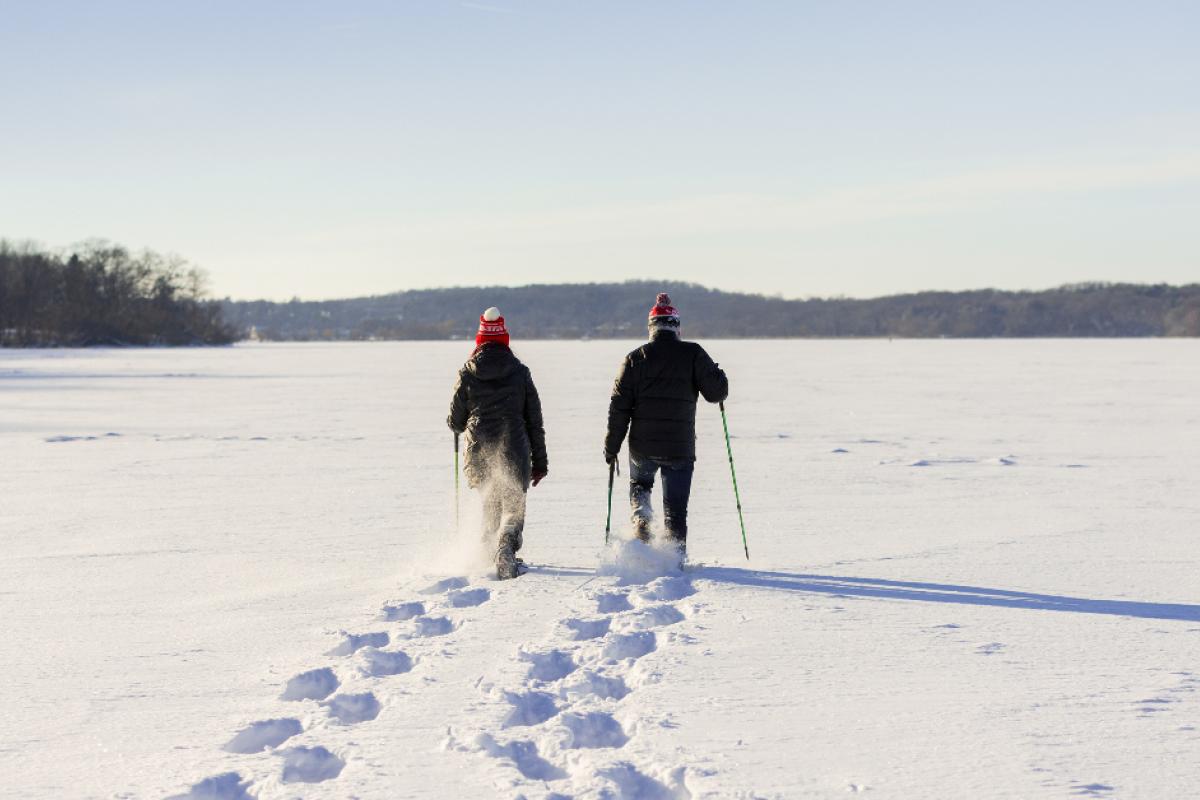 Two people walking through snow with snowshoes