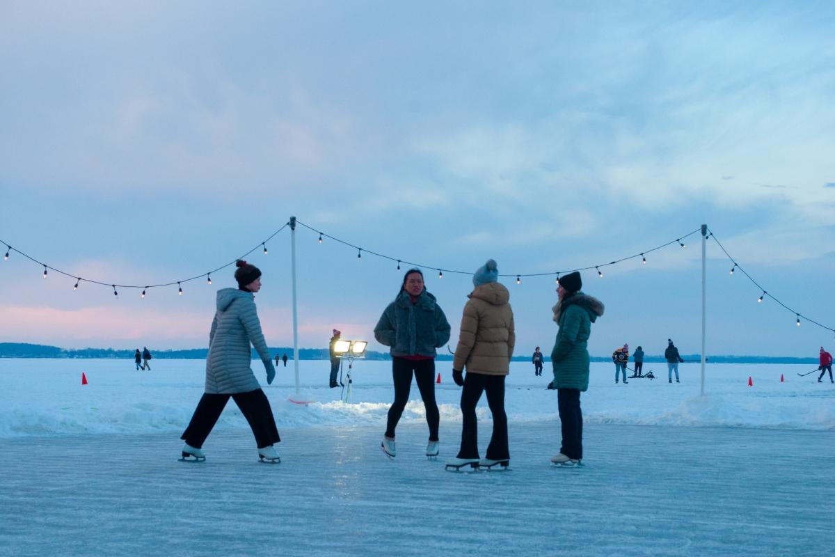People learning to skate on the frozen lake at Winter Carnival