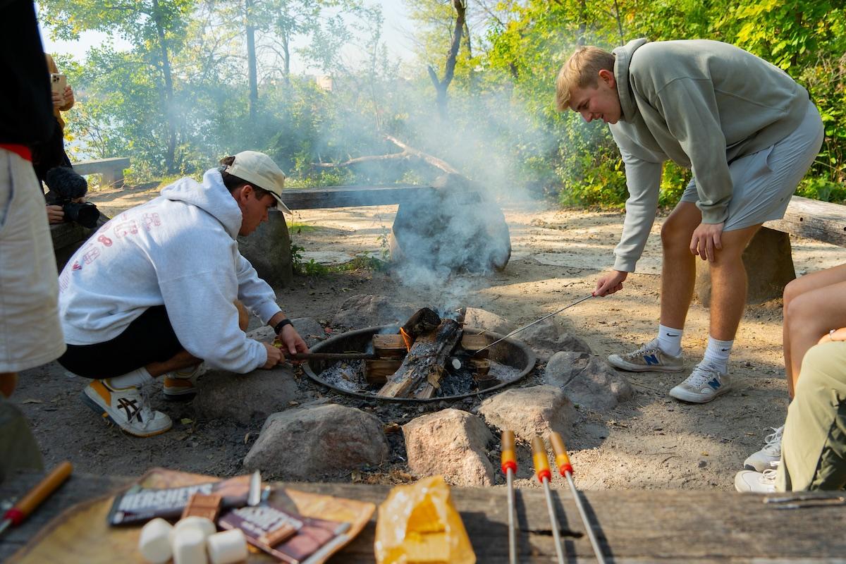 Two people roast smores over a fire pit
