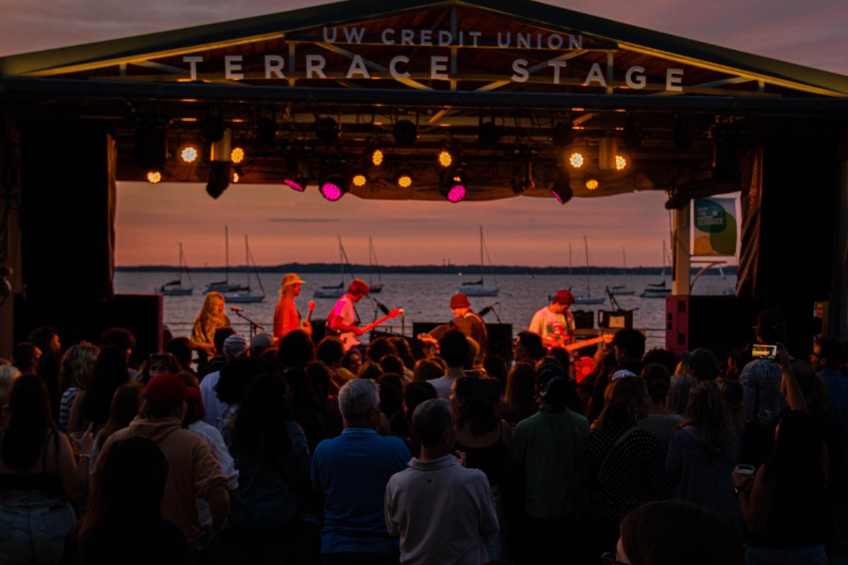 Individuals listening to a performance on the UW Credit Union Terrace Stage