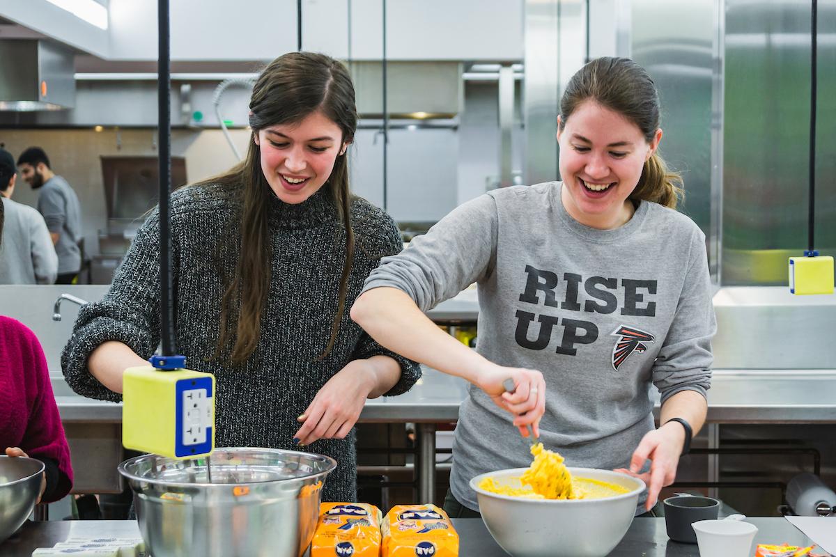 Participants in a WUD Cuisine Cooking Workshop stir empanada ingredients in mixing bowls