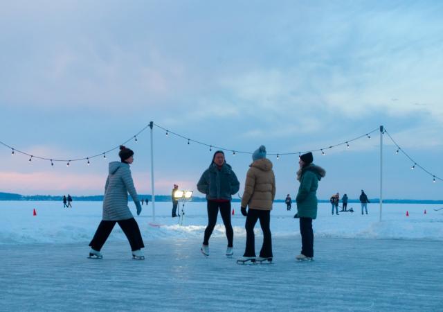 People learning to skate on the frozen lake at Winter Carnival